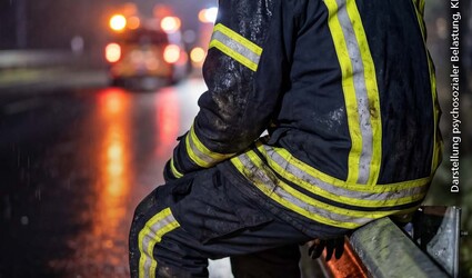 Das Bild zeigt einen Feuerwehrmann sitzend auf einer Leitplanke