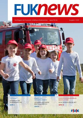 Kinder aus der Kinderfeuerwehr stehen vor einem Feuerwehrfahrzeug