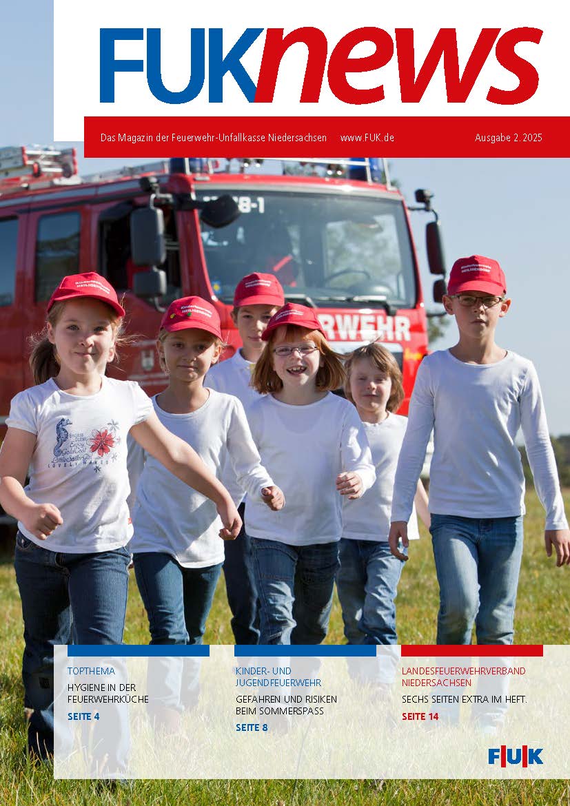 Kinder aus der Kinderfeuerwehr stehen vor einem Feuerwehrfahrzeug